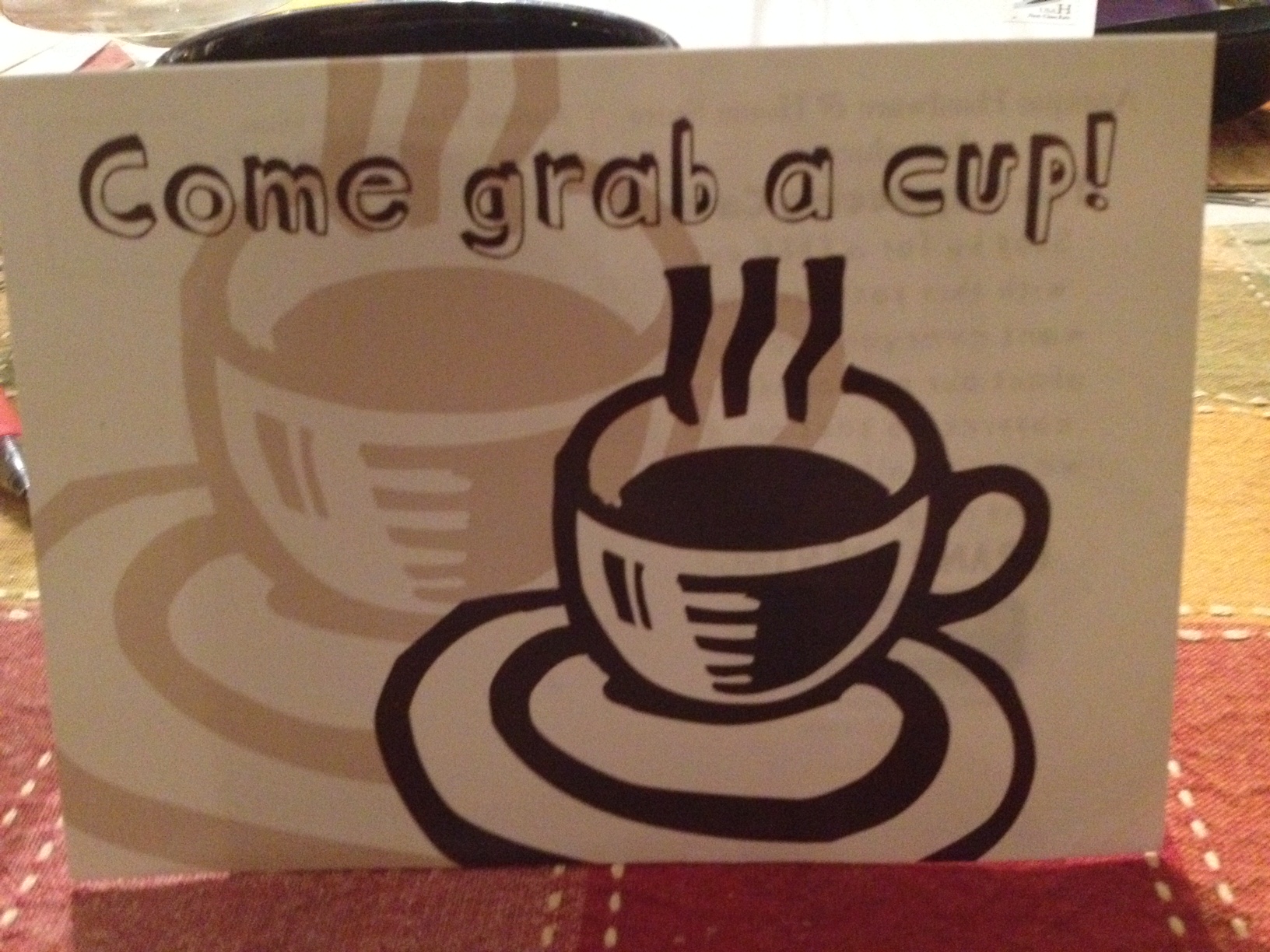 Photo showing a 'Come grab a cup' placard